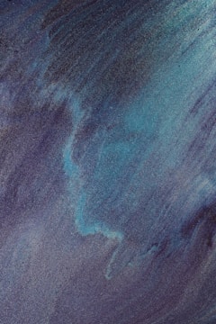 Swirling patterns of blue and teal colors blend seamlessly, creating a textured, ethereal effect reminiscent of waves or flowing energy.