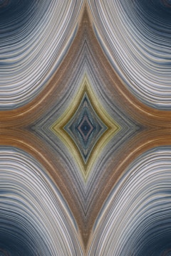 An abstract design featuring a symmetrical, kaleidoscopic pattern with curved lines converging towards a central diamond shape. The lines exhibit a variety of textures and gradients, creating an intricate visual effect reminiscent of layered fabric or natural formations.