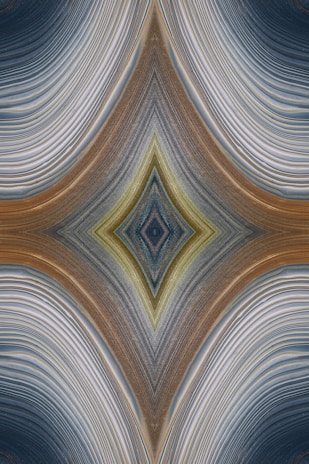 An abstract design featuring a symmetrical, kaleidoscopic pattern with curved lines converging towards a central diamond shape. The lines exhibit a variety of textures and gradients, creating an intricate visual effect reminiscent of layered fabric or natural formations.