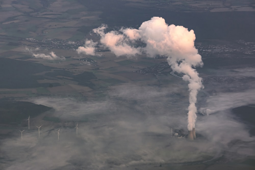 a factory emits steam as it rises into the sky