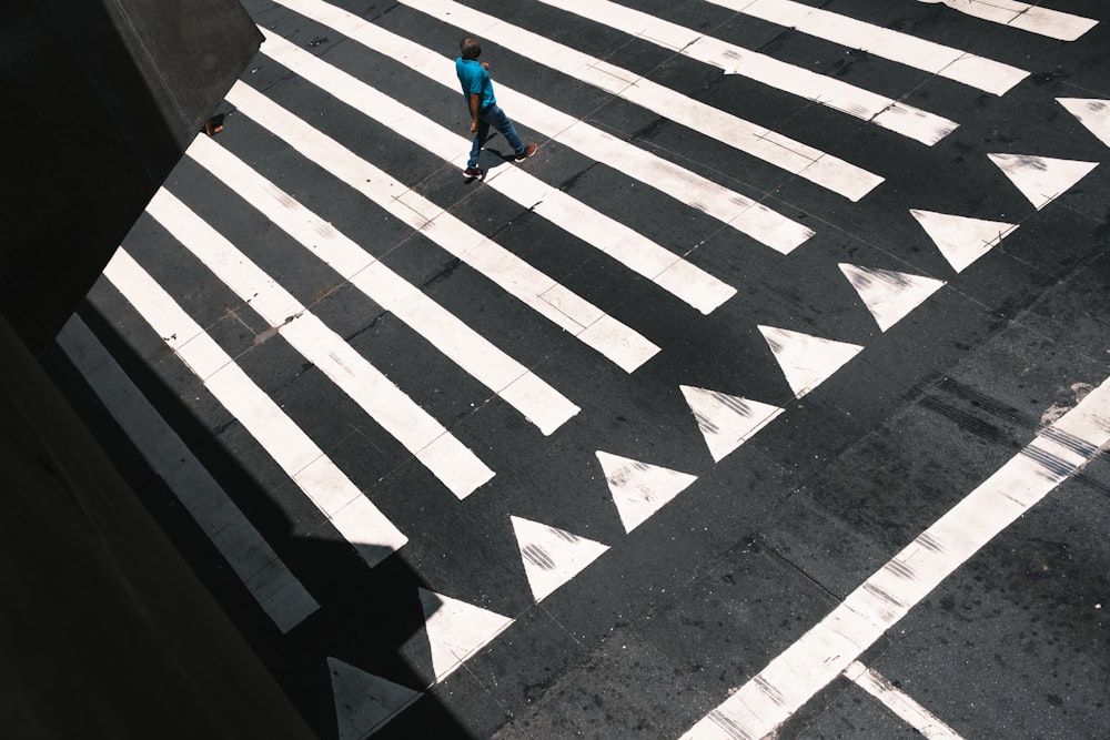 a person walking across a crosswalk in the middle of a street