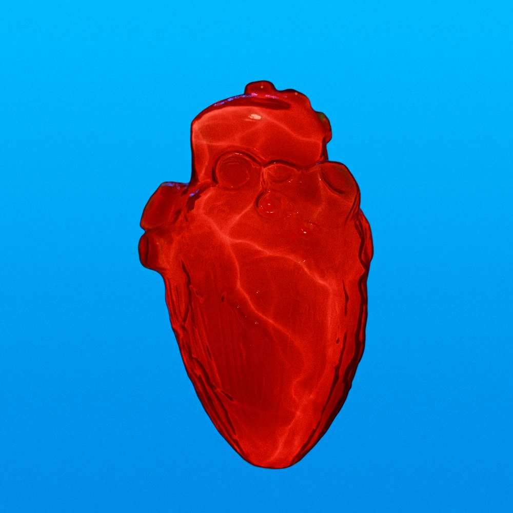 a red heart shaped object floating in the air