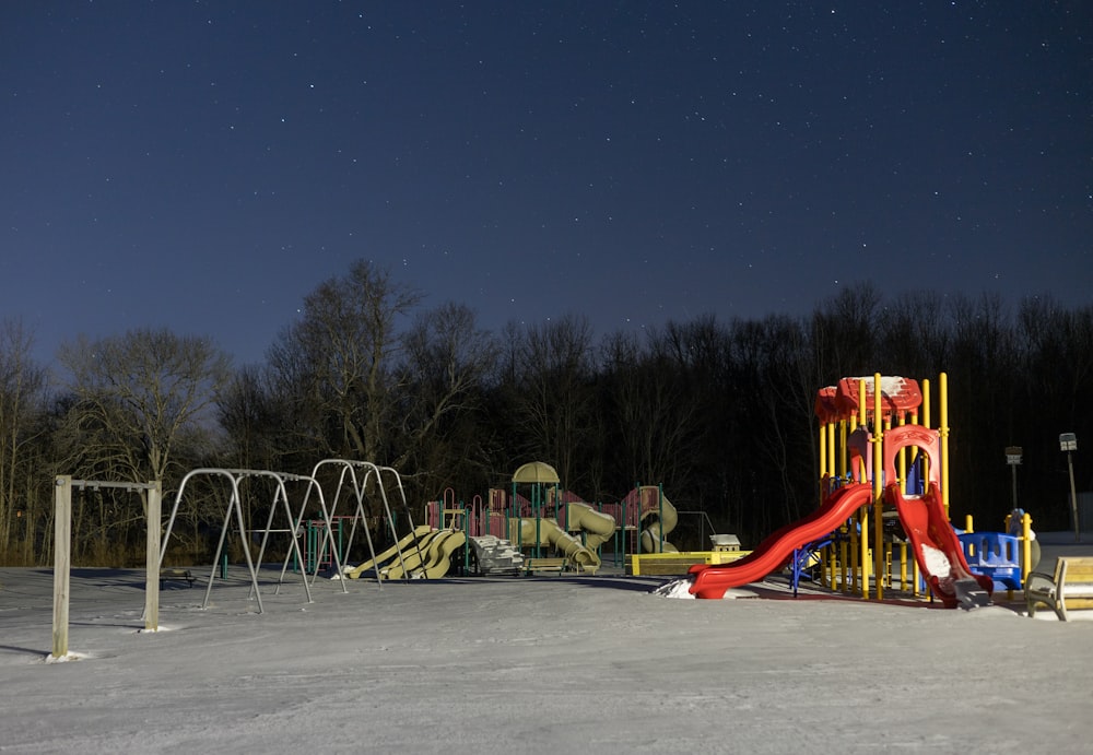 a children's play area in the middle of a snow covered field