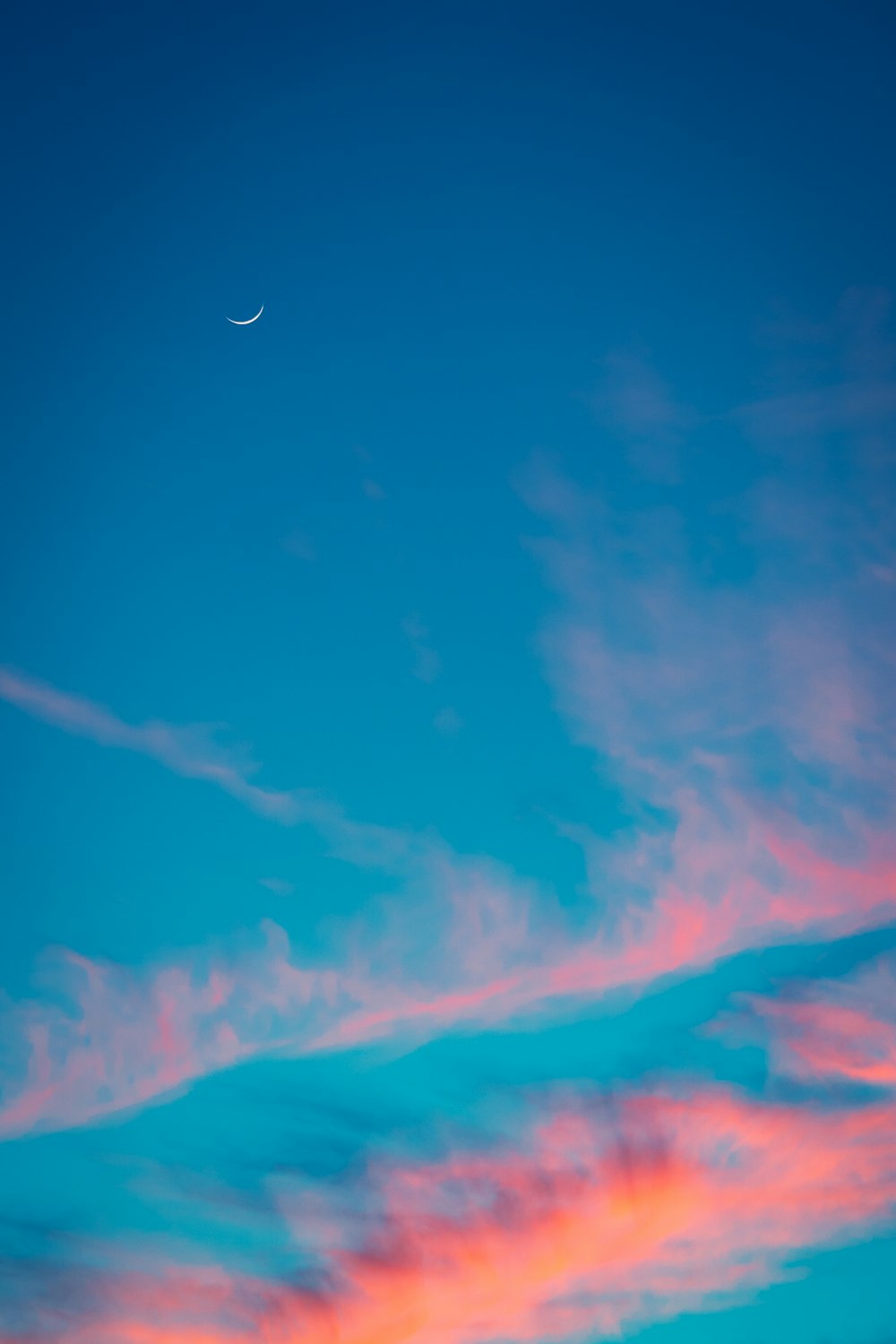 a plane flying in the sky at sunset