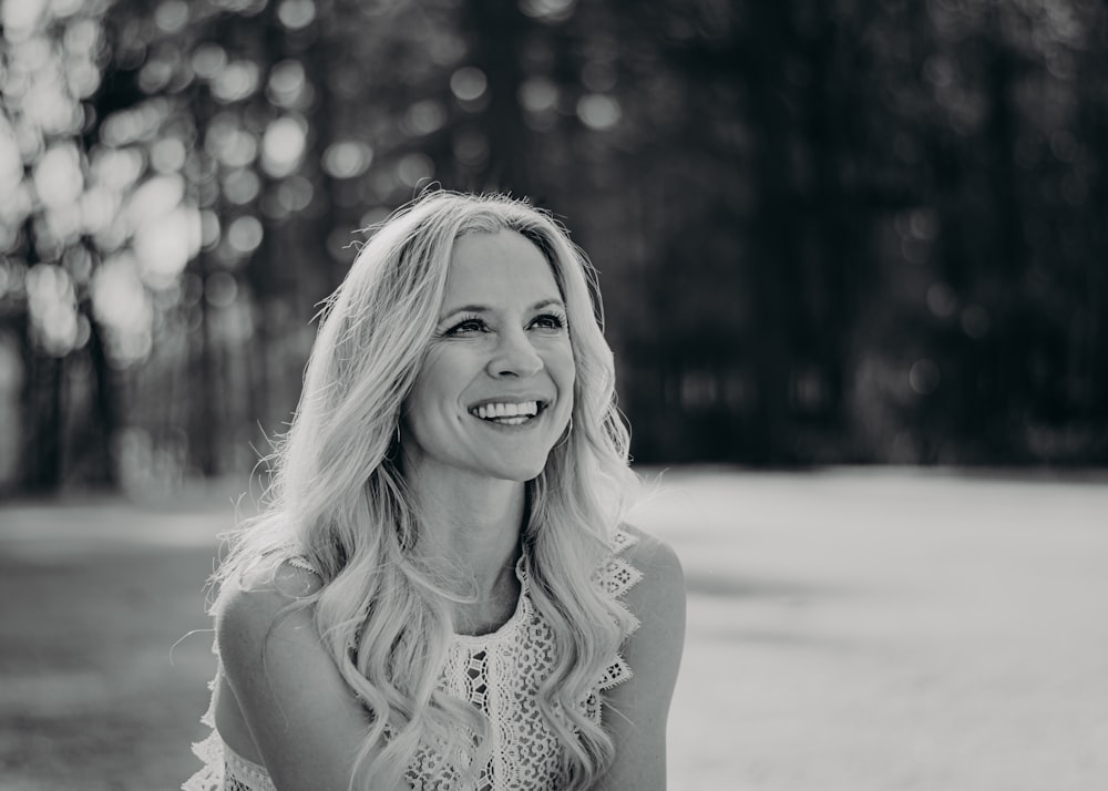 a woman sitting on the ground with a smile on her face