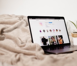 a laptop computer sitting on top of a bed