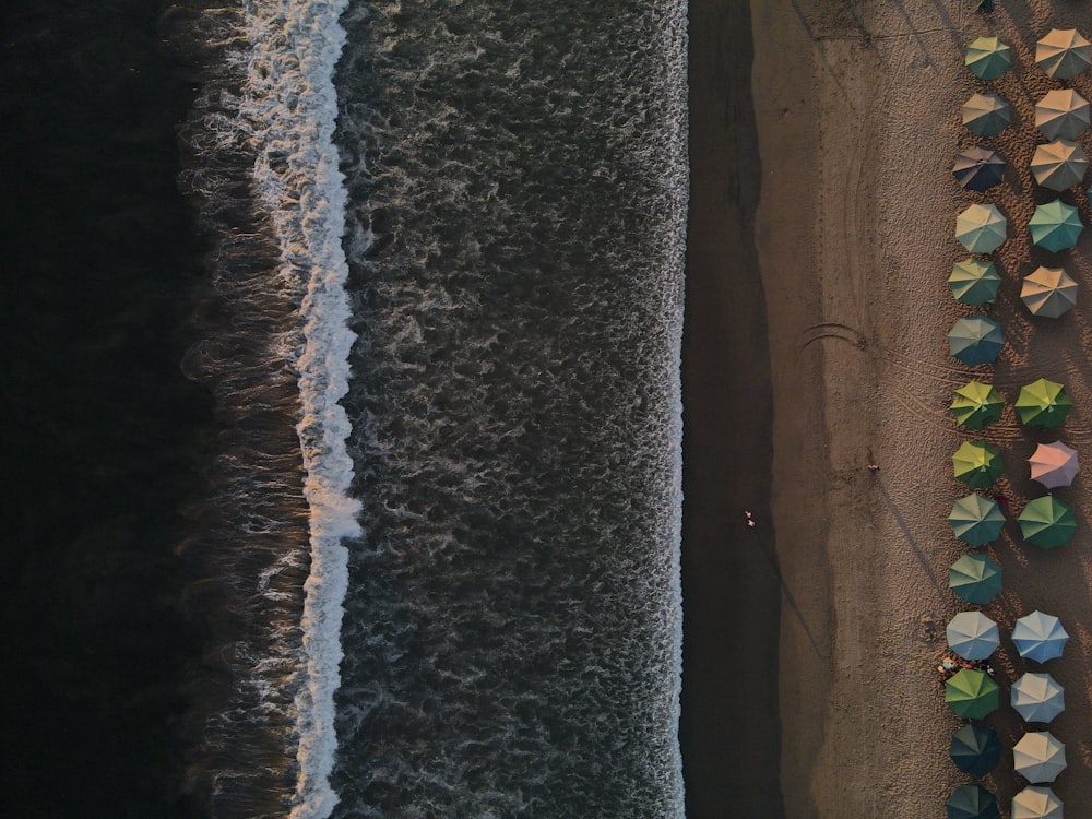 an aerial view of a beach with umbrellas