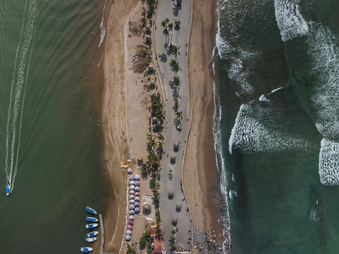 an aerial view of a beach with boats in the water,