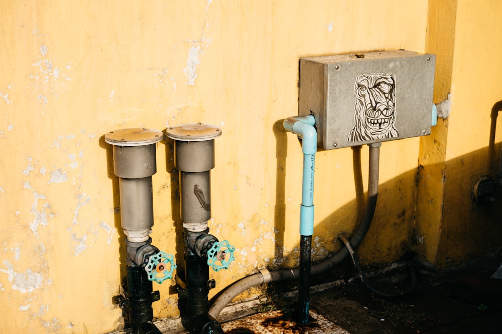 a couple of pipes that are next to a wall