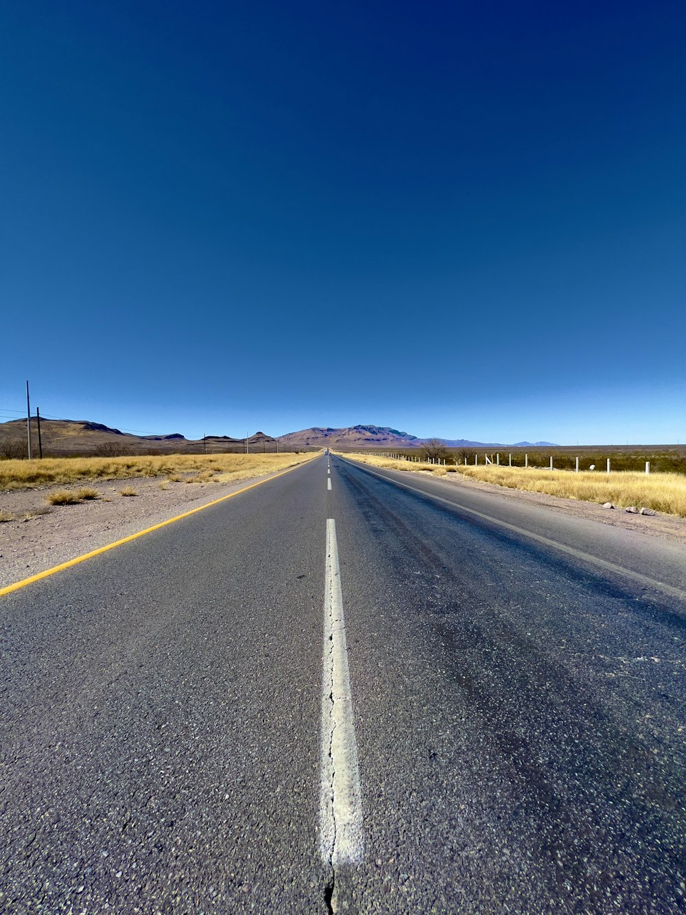 an empty road in the middle of the desert