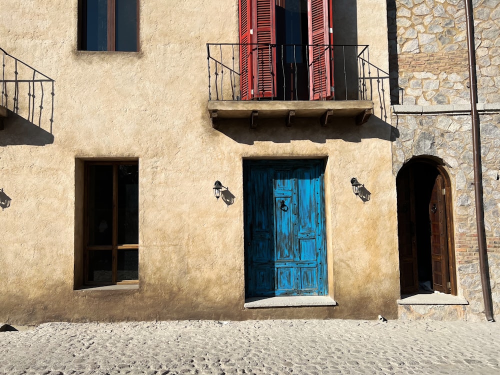 a blue door is in front of a tan building