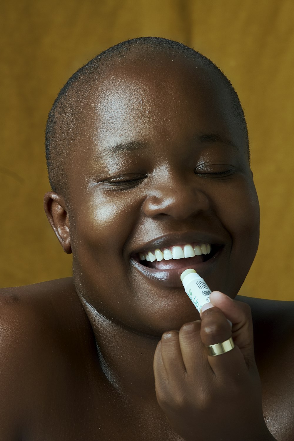 a woman smiles as she brushes her teeth