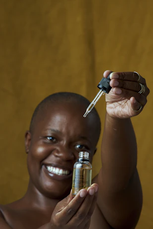 a woman holding a small bottle with a key in it