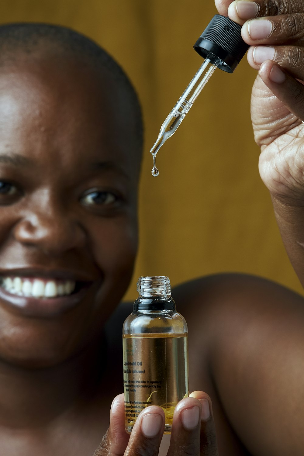 a woman holding a bottle of medicine with a dropper