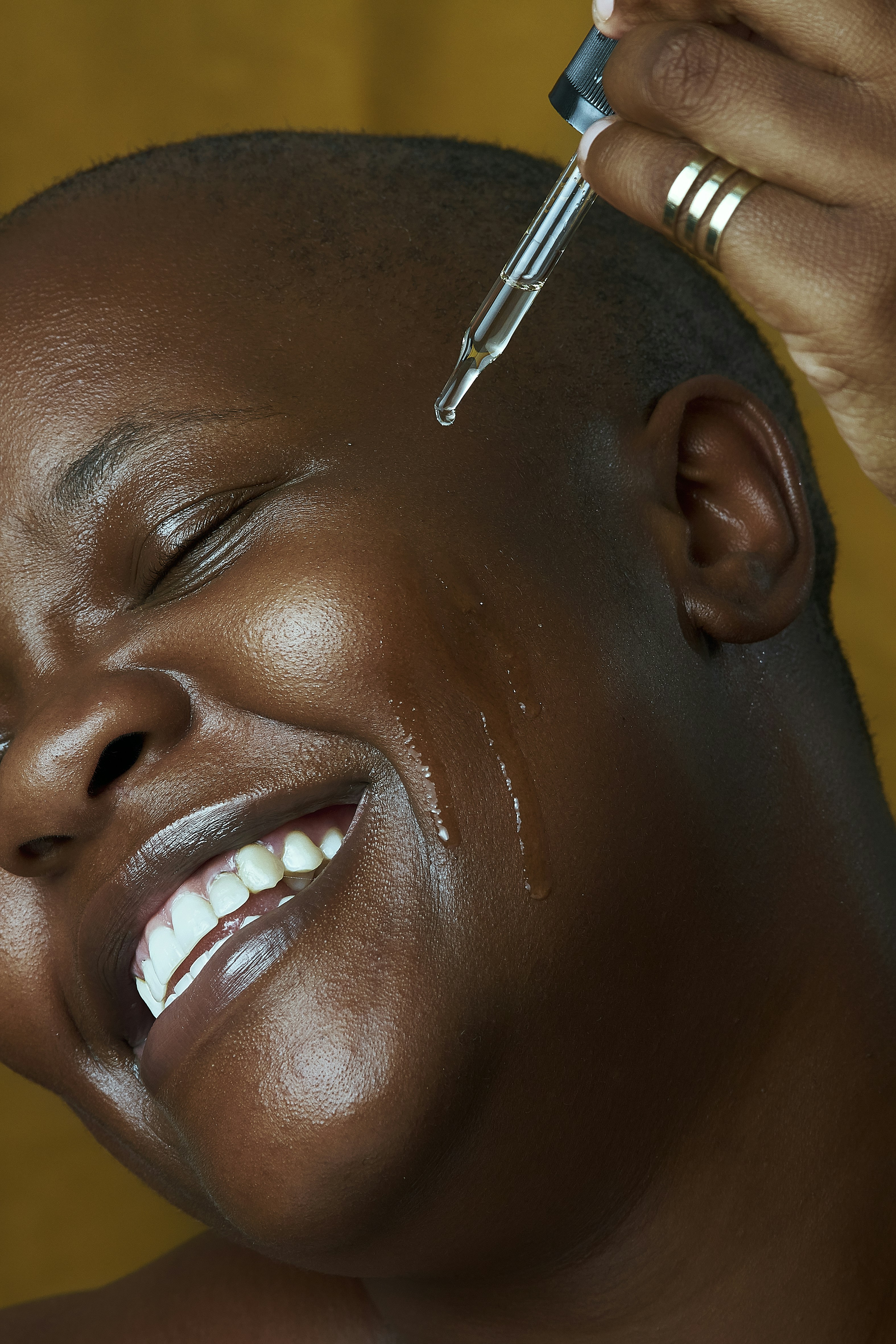 a woman is smiling while she is getting her hair brushed