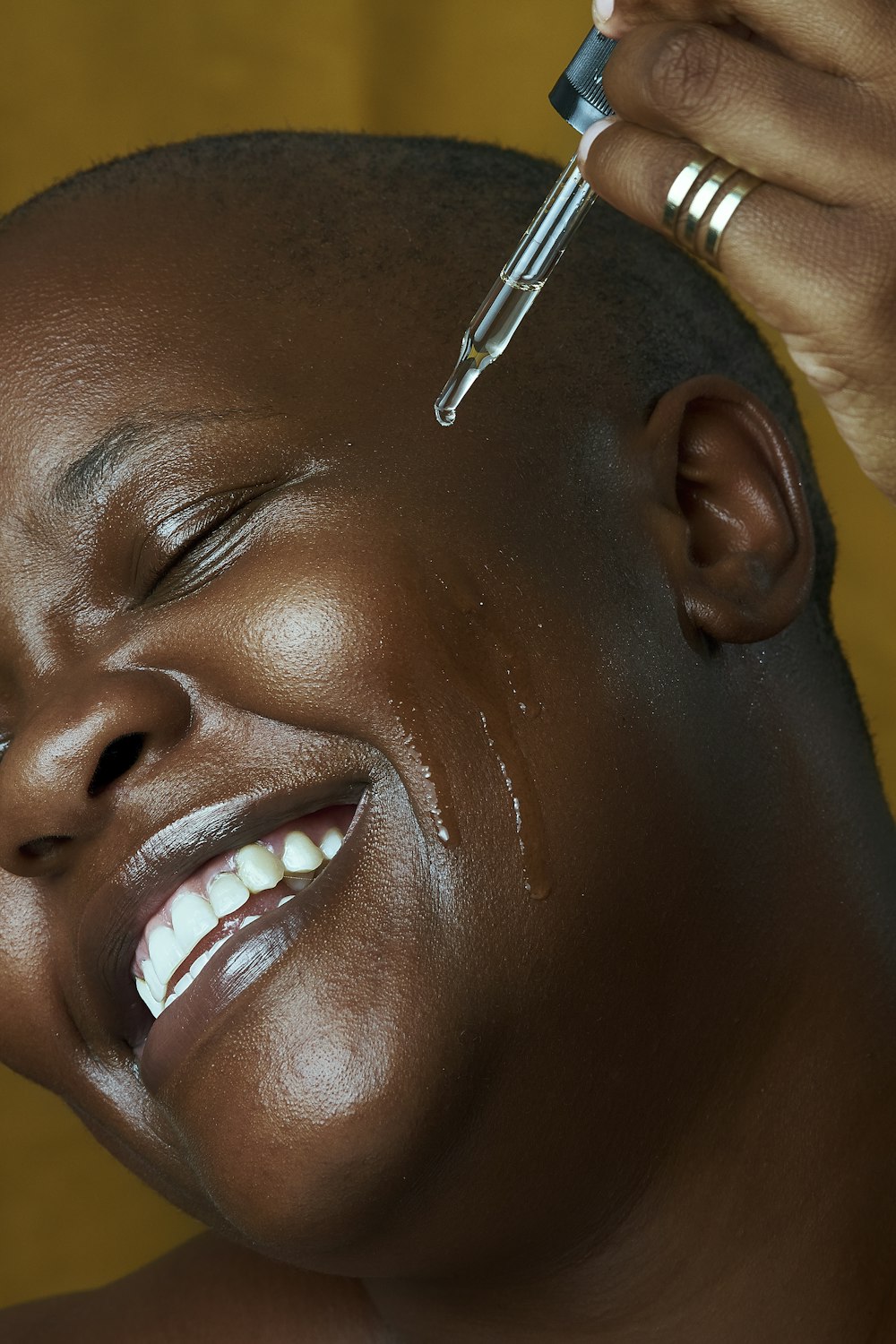 a woman is smiling while she is getting her hair brushed