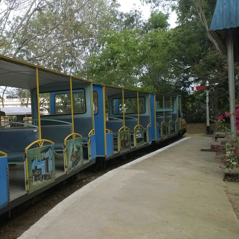 a blue and yellow train traveling down train tracks