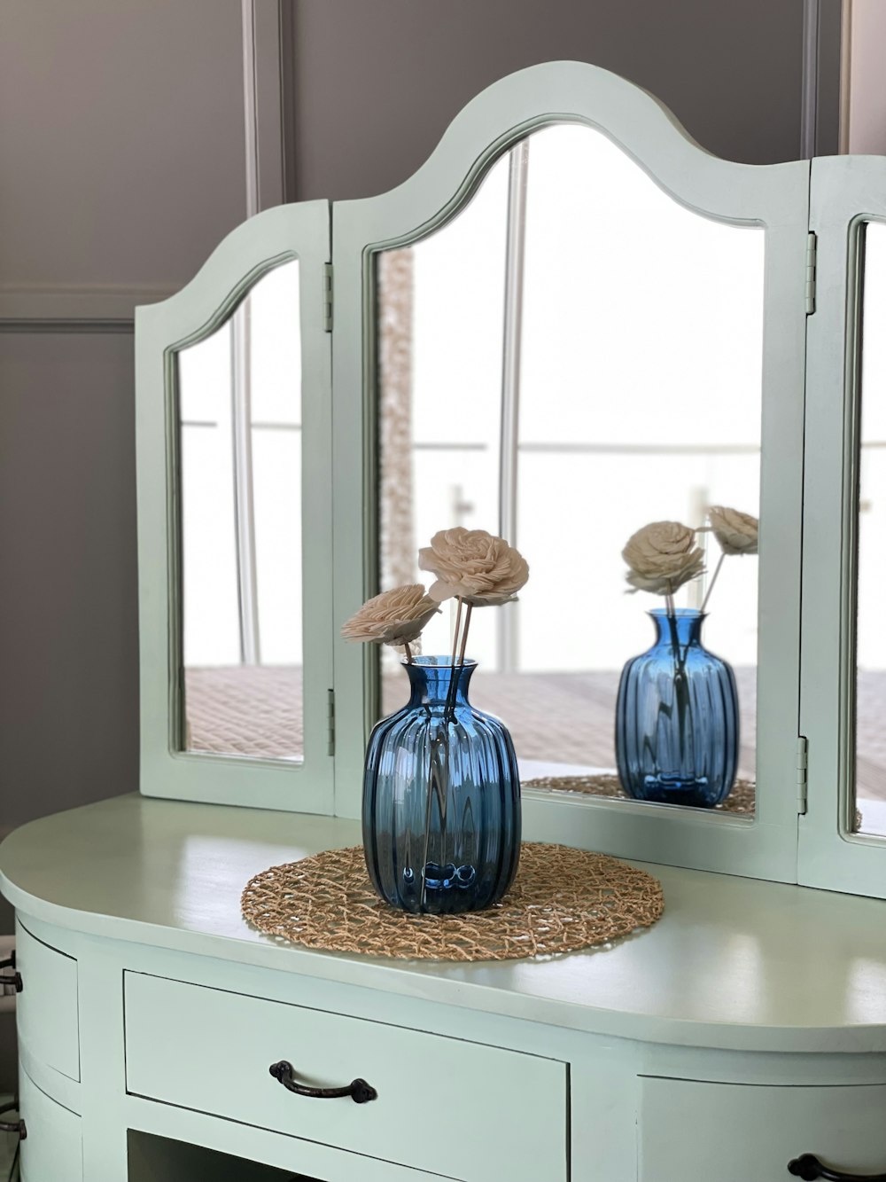 a dresser with a mirror and two vases on it