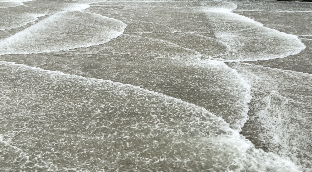 uma foto em preto e branco das ondas na praia