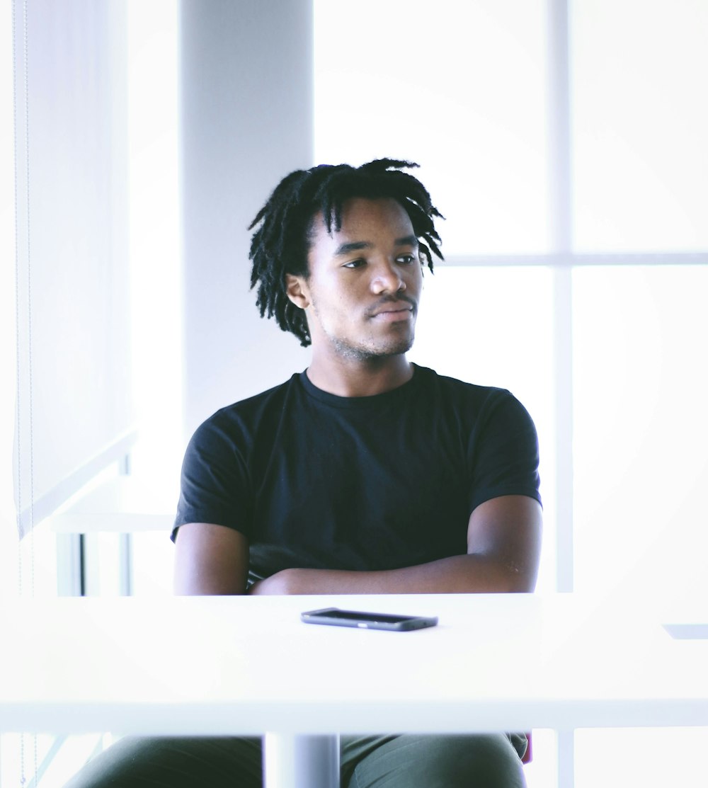 a man with dreadlocks sitting at a table