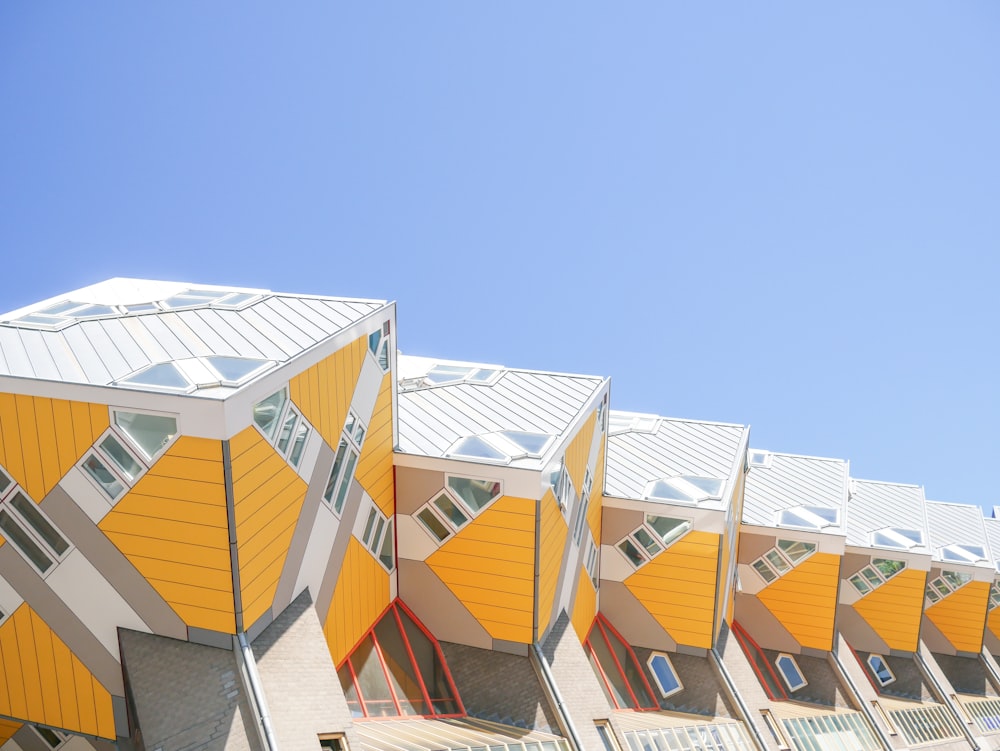 a row of yellow and white buildings with a blue sky in the background