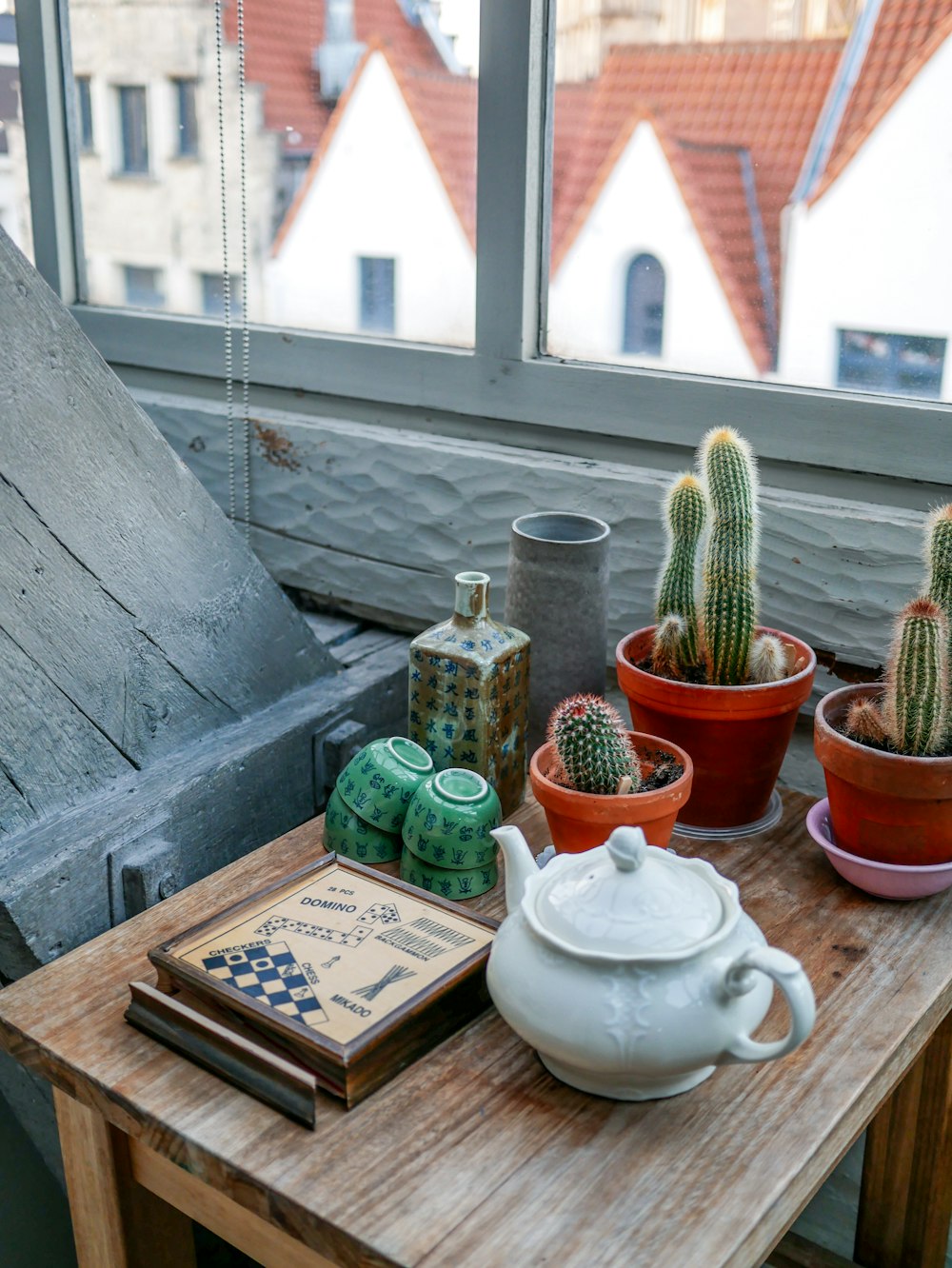 a wooden table topped with potted plants next to a window