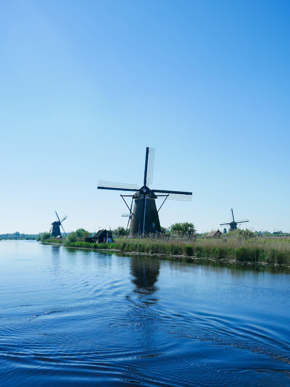 a group of windmills sitting on the side of a river