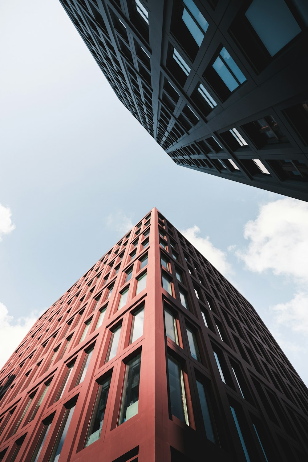 looking up at a tall red building in a city