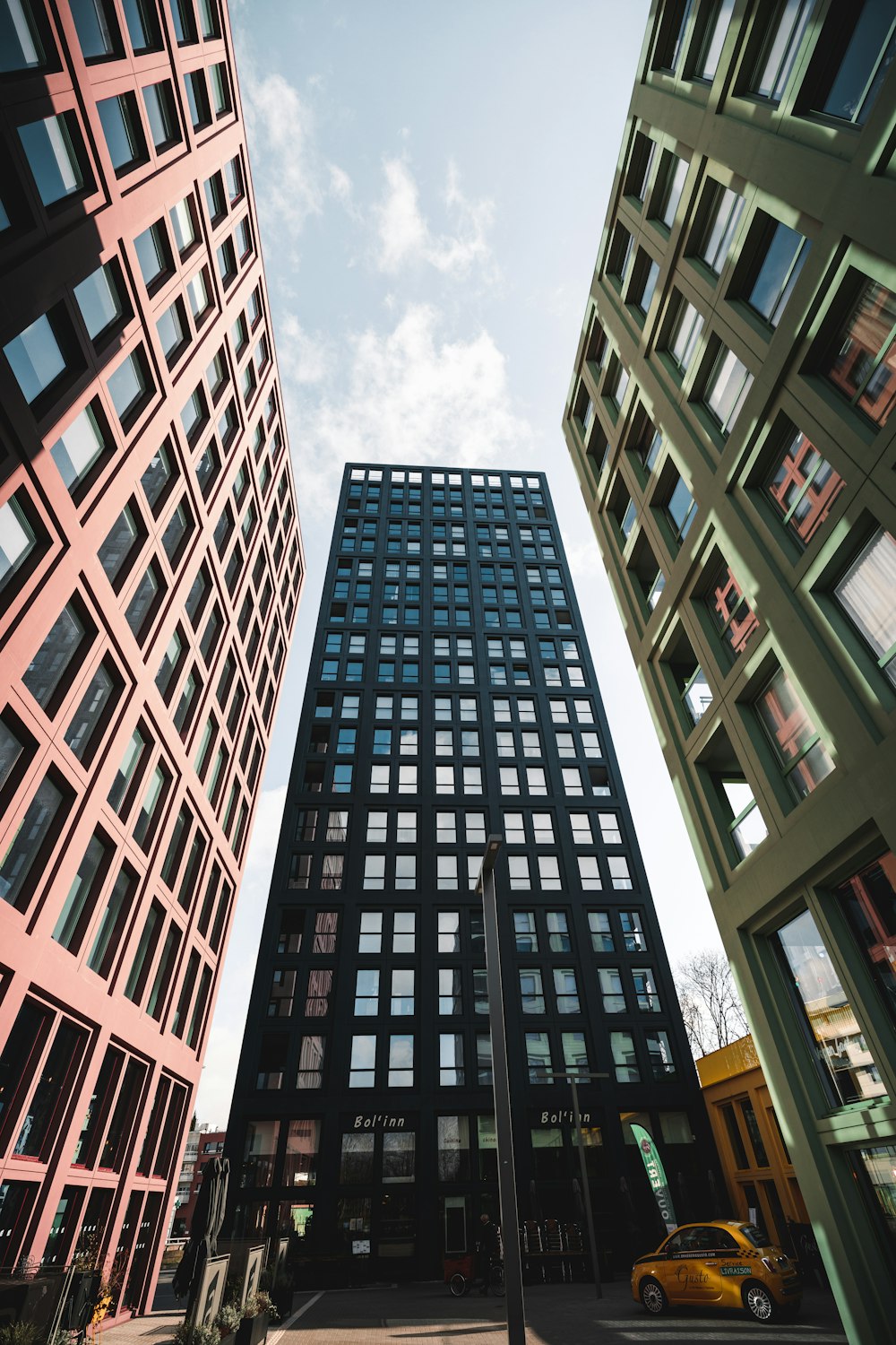 um edifício alto com muitas janelas ao lado de outros edifícios