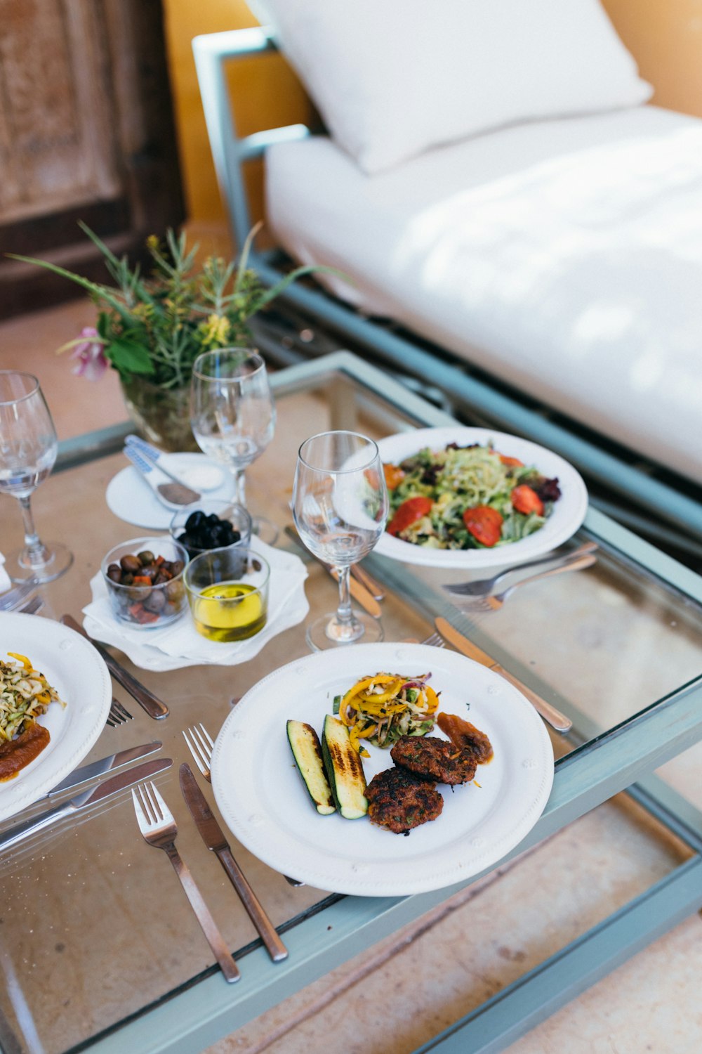 a glass table topped with plates of food