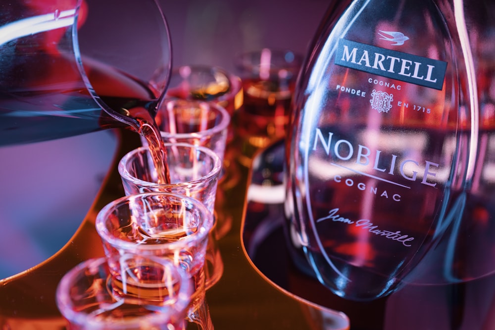 a group of glasses sitting next to a bottle of wine