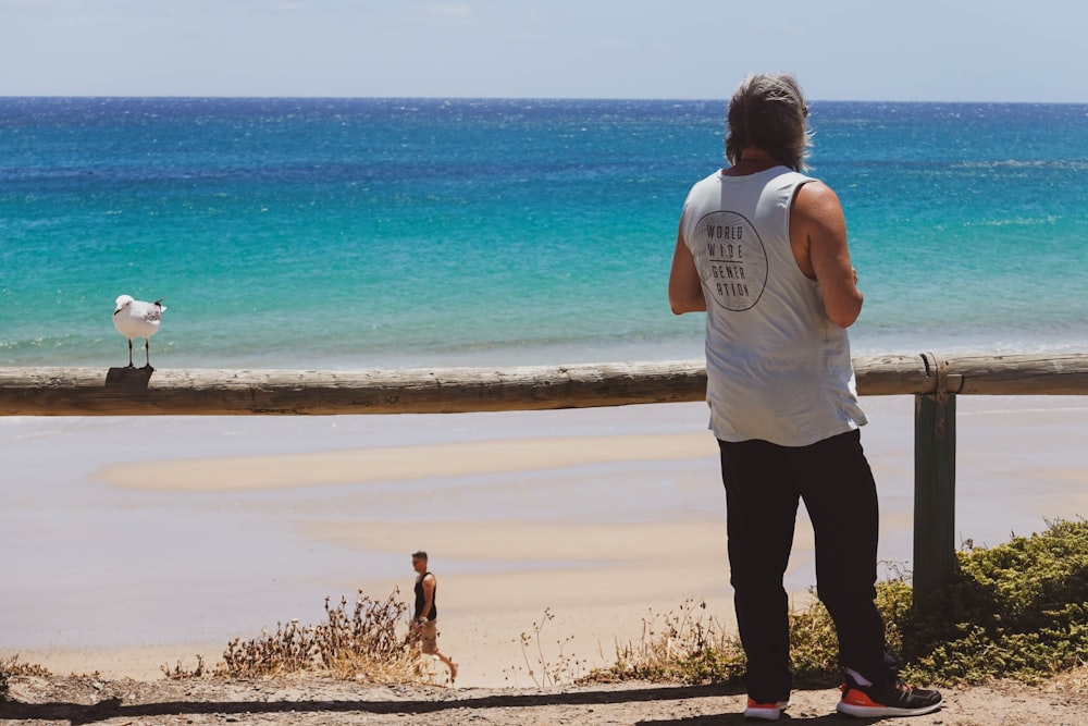 a man standing on a beach next to the ocean