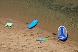 a group of surfboards sitting on top of a sandy beach