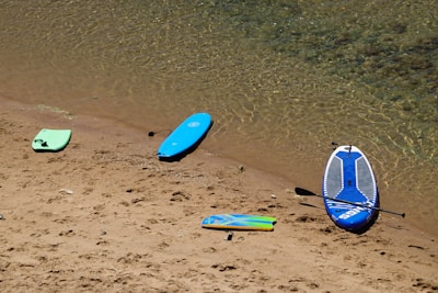 a group of surfboards sitting on top of a sandy beach