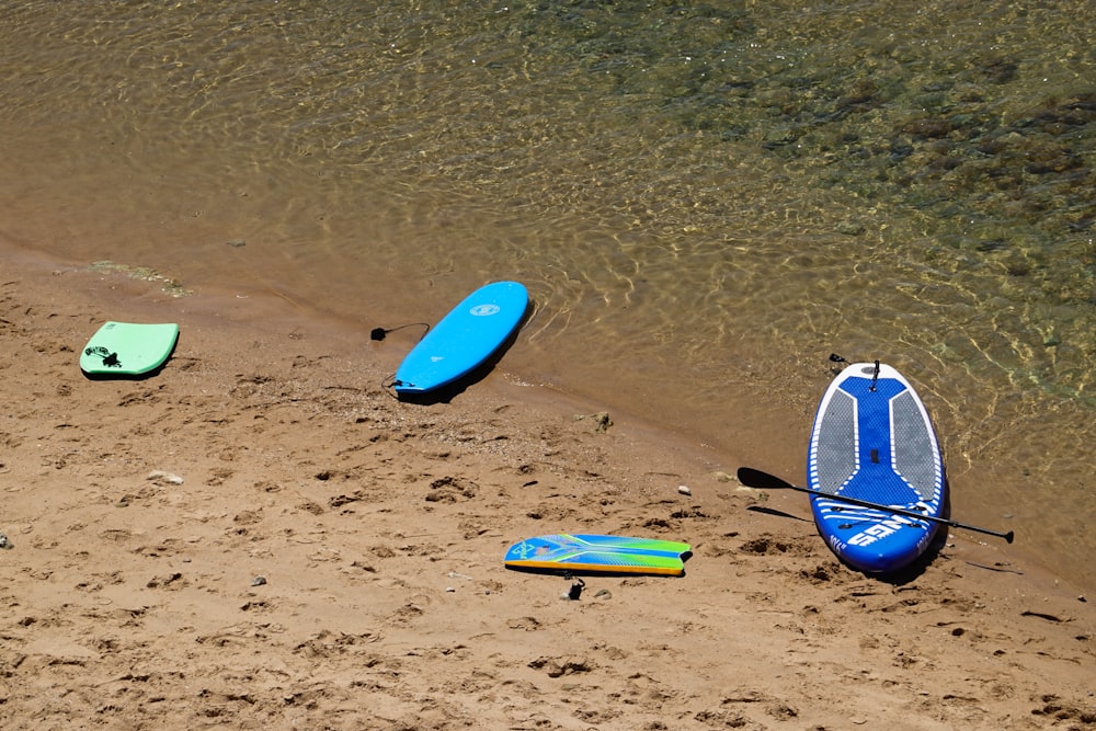 Un grupo de tablas de surf sentadas en la cima de una playa de arena