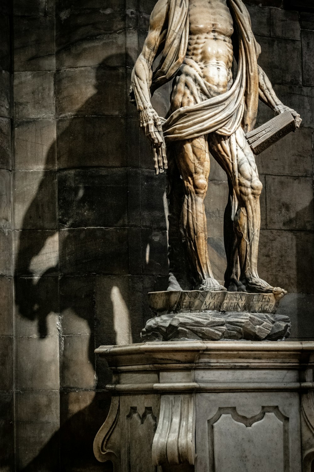 a statue of a man standing next to a wall