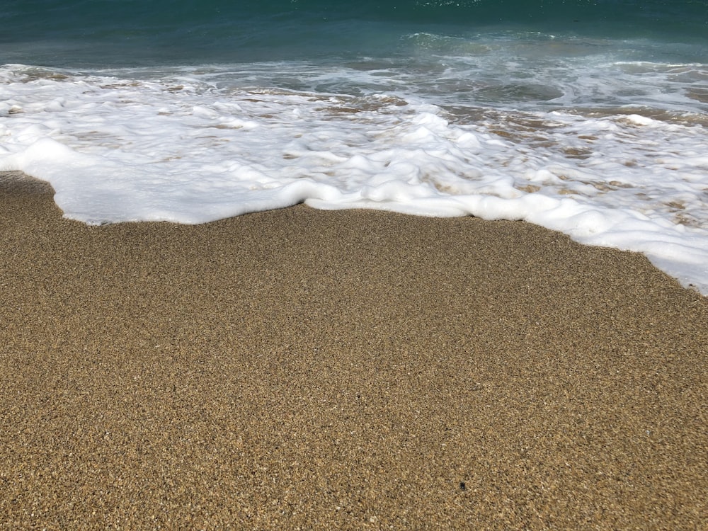 a sandy beach with waves coming in to shore