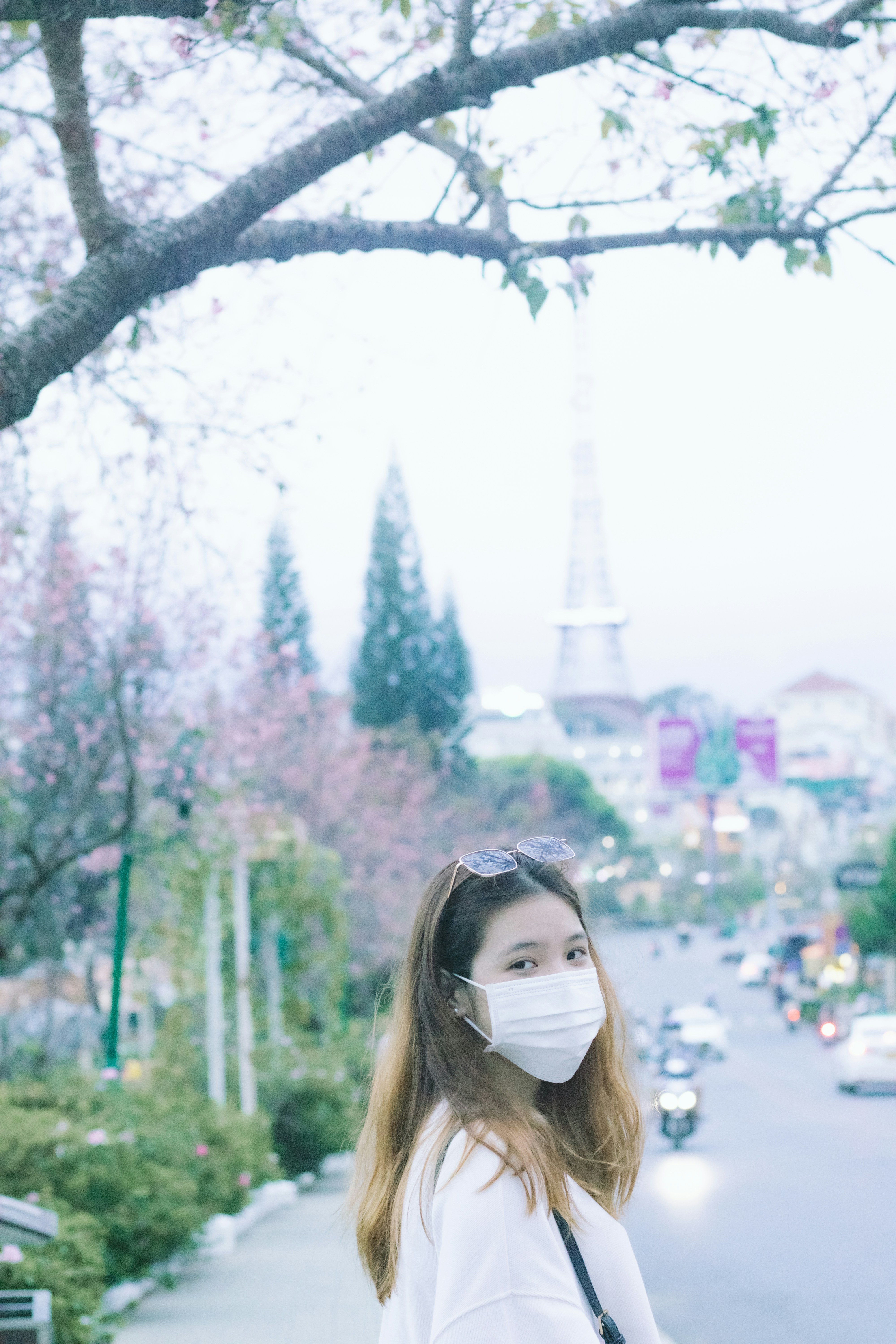 a woman wearing a face mask standing on a sidewalk