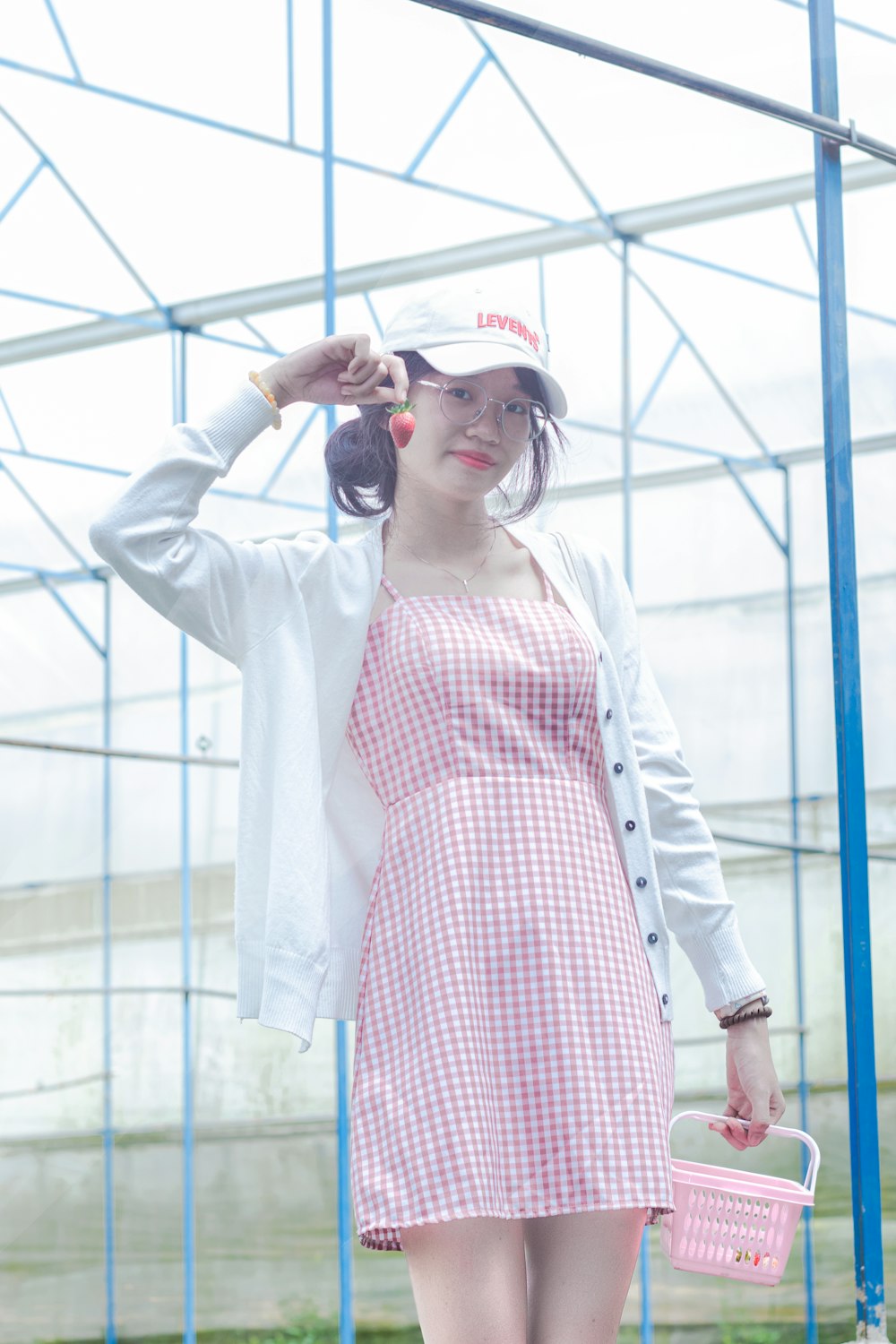 a woman in a red and white dress holding a pink basket