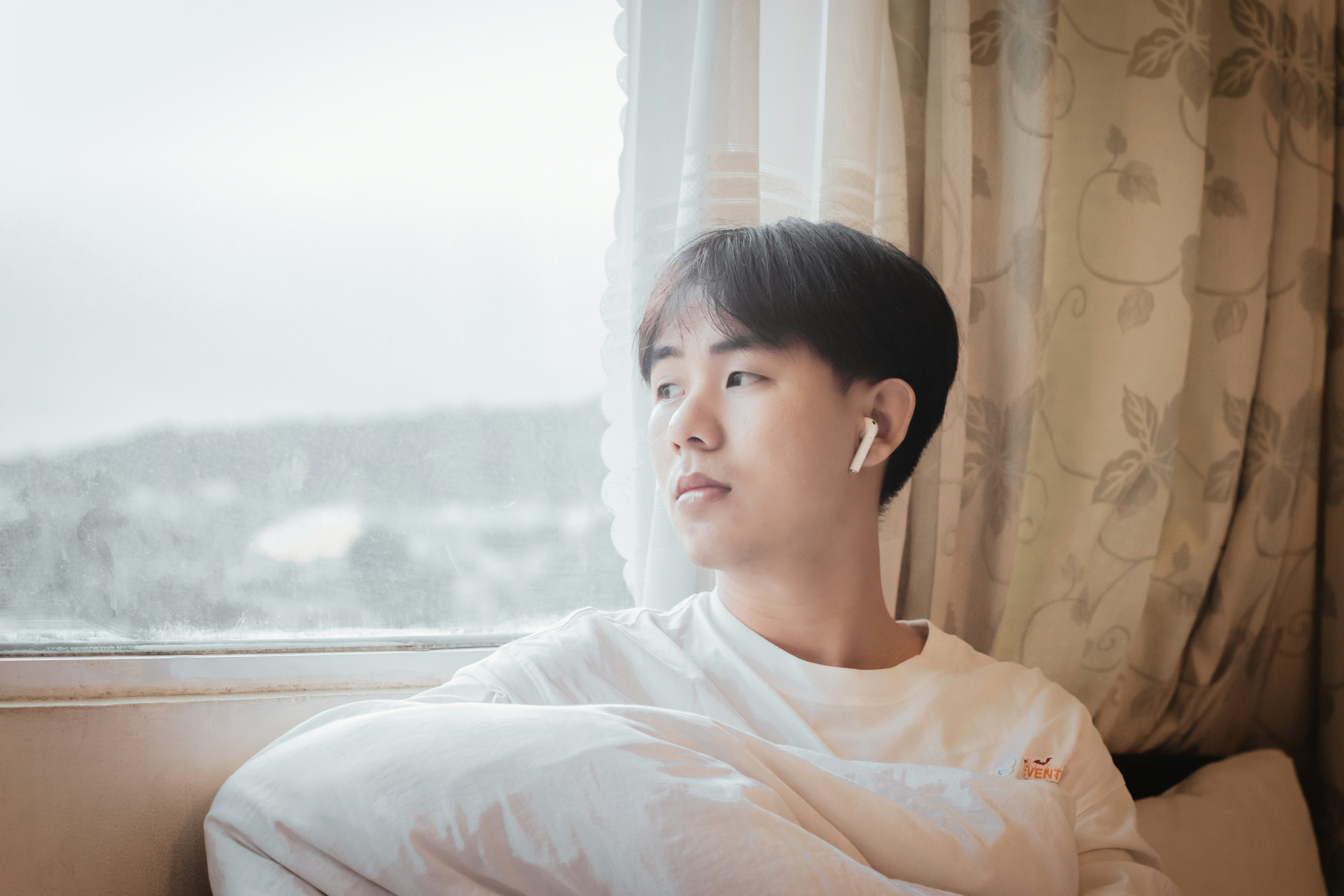 a woman sitting on a couch looking out a window