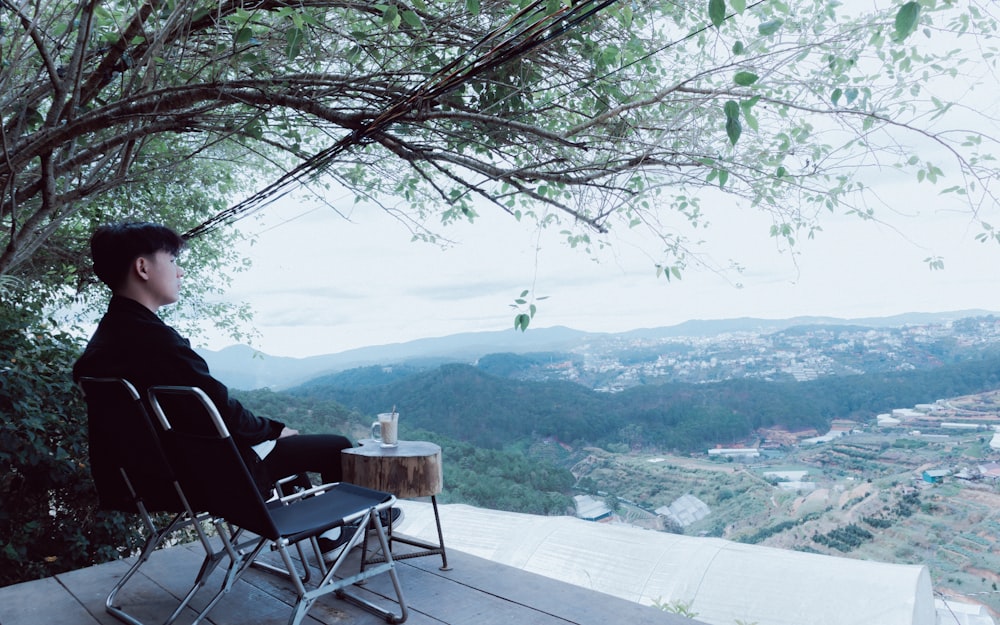 a man sitting in a chair on top of a wooden deck