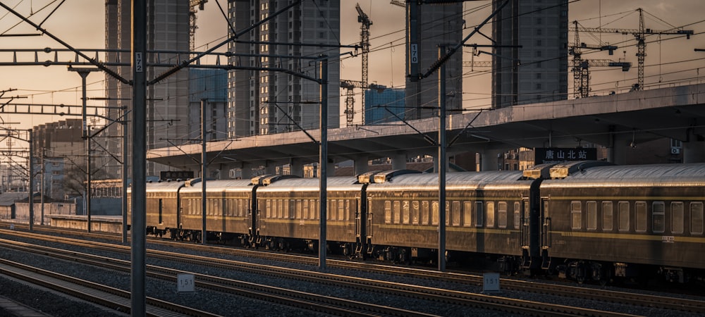 a train traveling down train tracks next to tall buildings