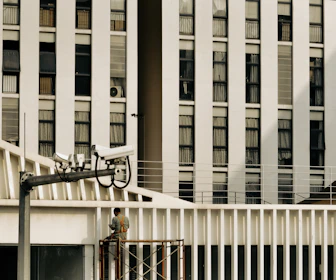 Technician installing a 3D sensor device on a commercial building wall.