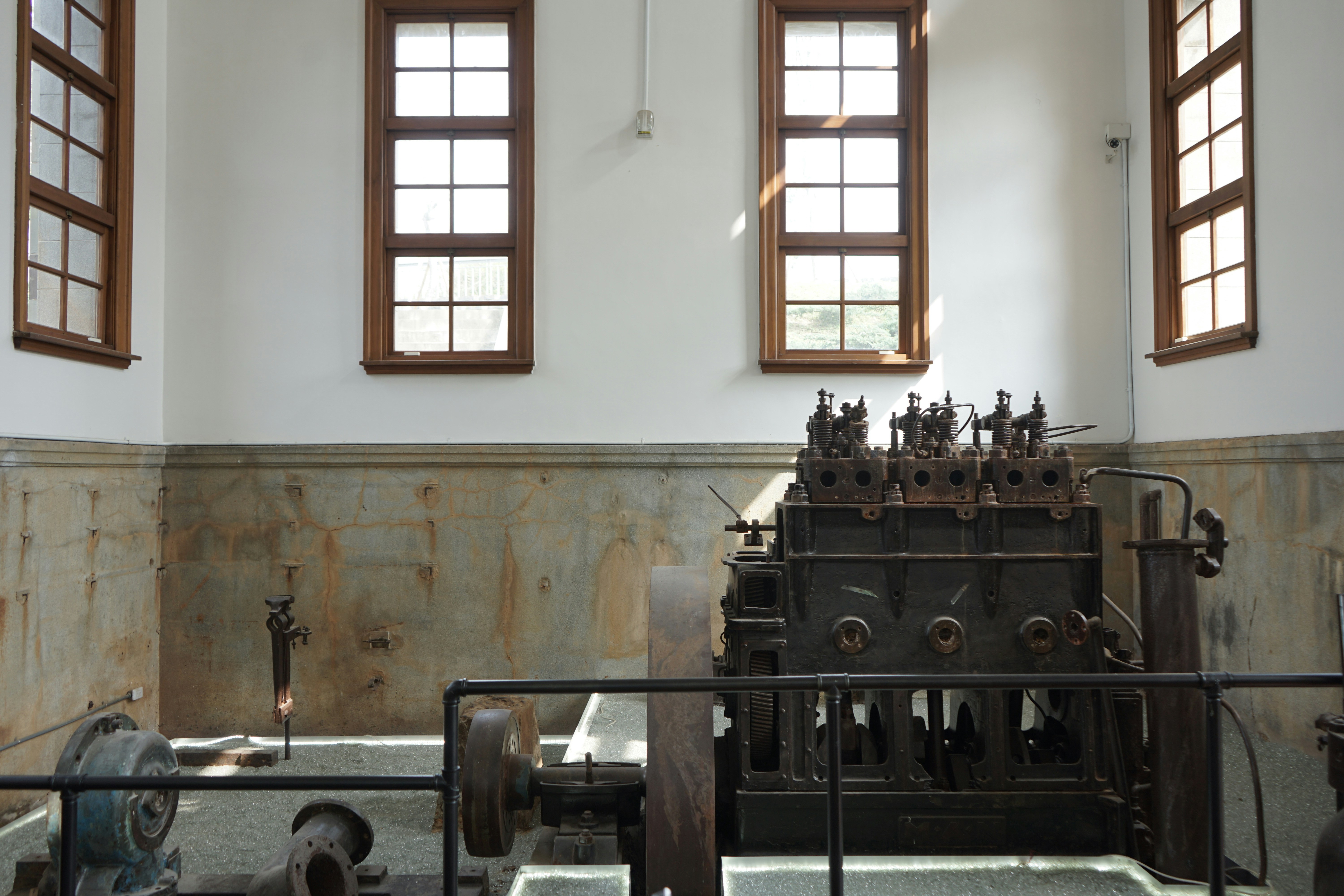 a large machine in a room with three windows