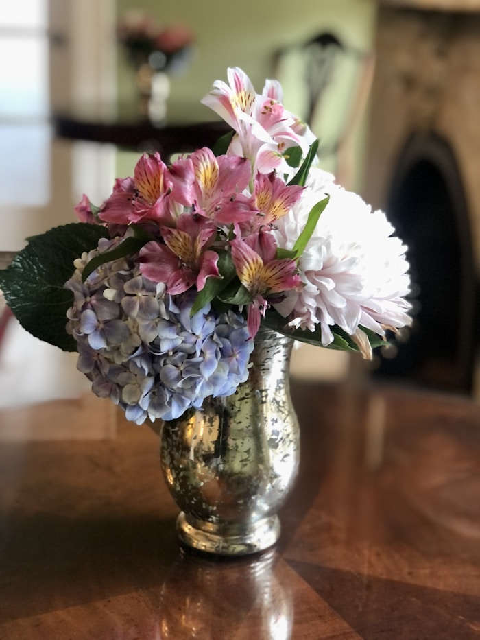 Bouquet hebdomadaire de fleurs de saison dans un vase ambré