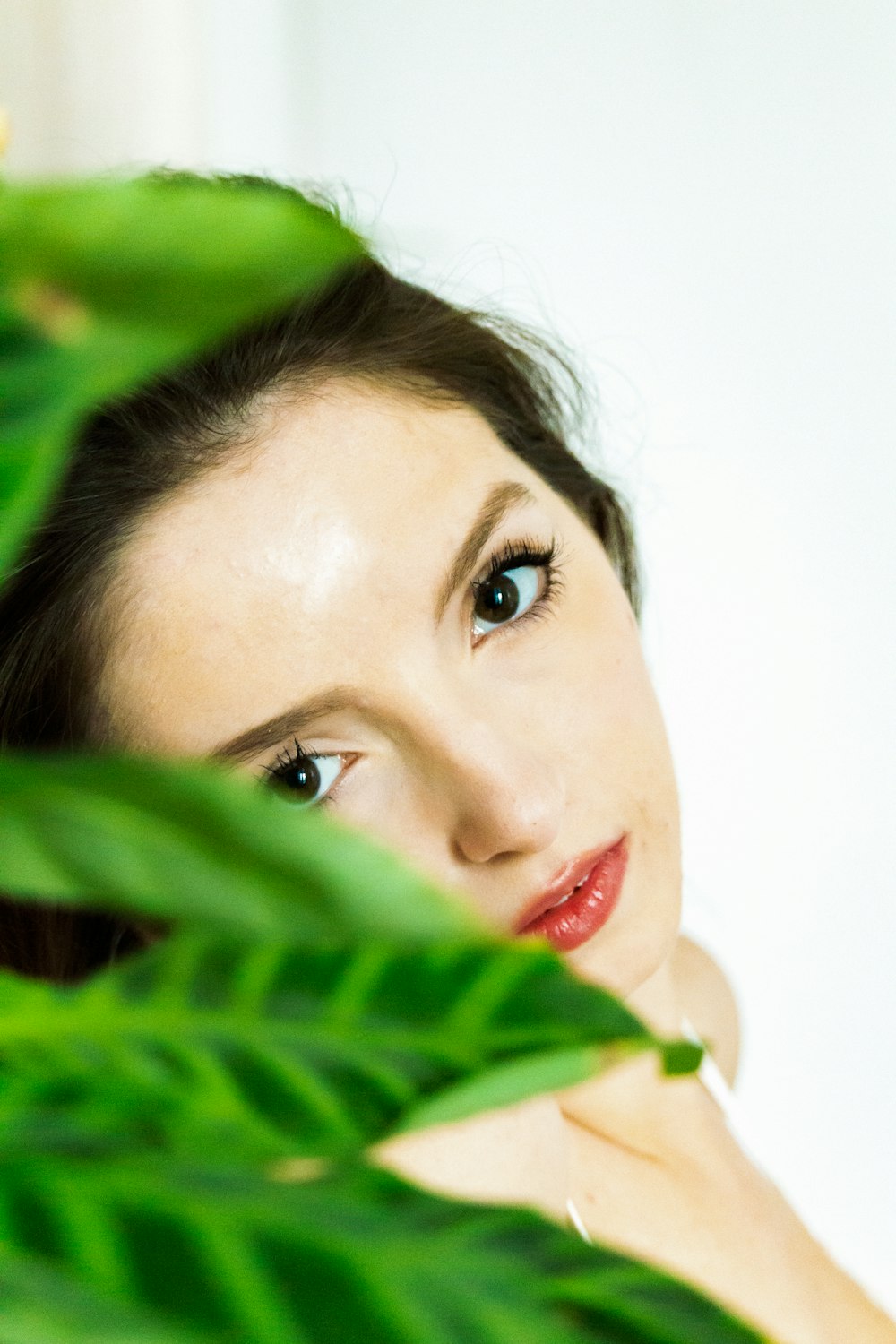 a woman with blue eyes and a green plant