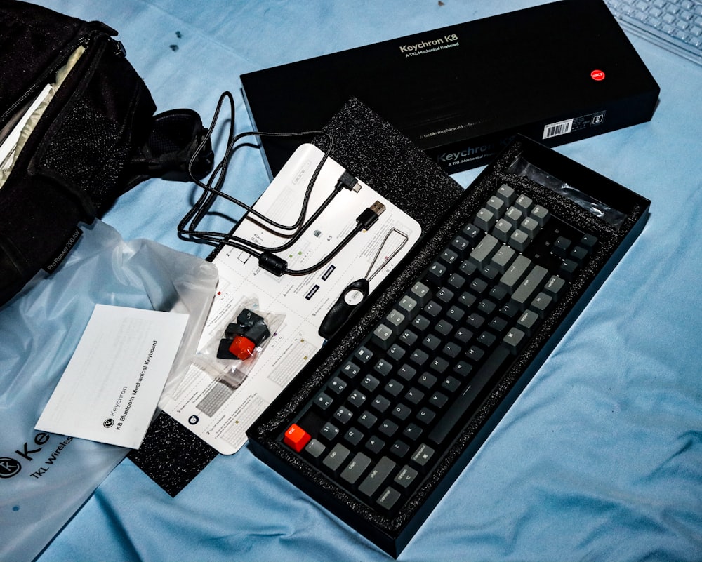 a keyboard and a bag on a bed