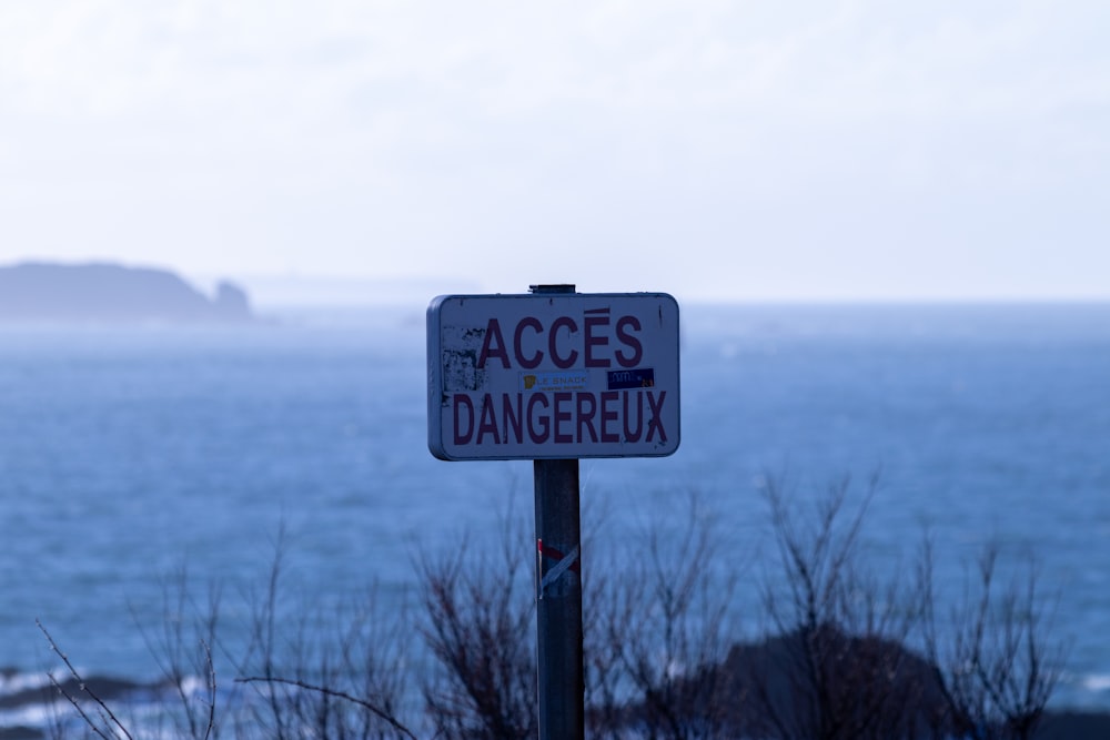 a sign on a pole near a body of water