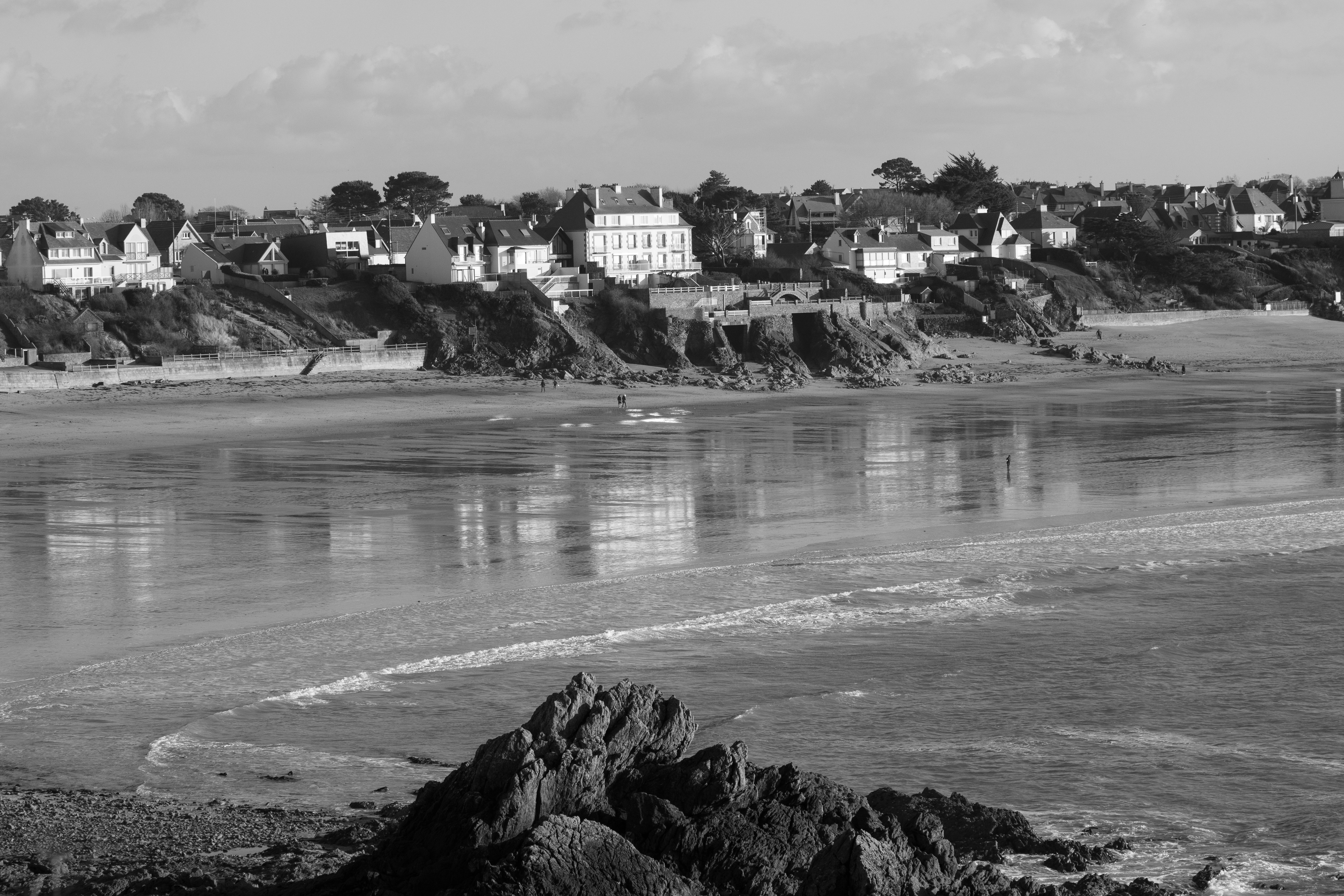 a black and white photo of houses on a beach