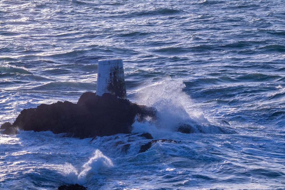 a small rock in the middle of a body of water